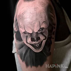 Tattoo Pennywise on the upper arm motif: dark style: realistic