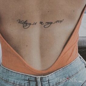 Tattoo Victory in the veins on the back motif: lettering style: calligraphy