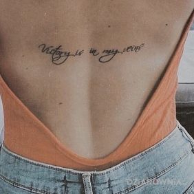 Tatuaż Zwycięstwo w żyłach na plecach motyw: napisy styl: kaligrafia