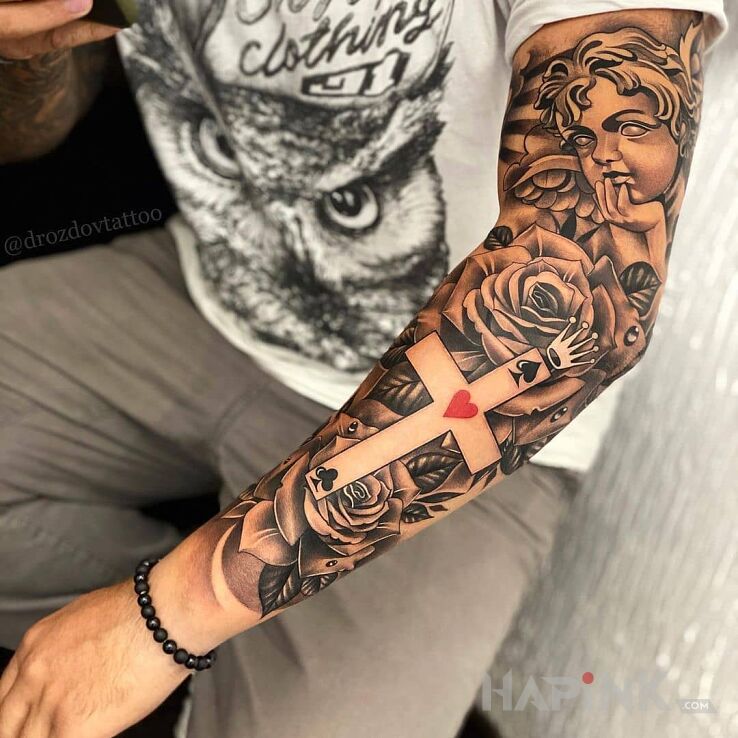 Tattoo Królewski krzyż in flowers motif and realistic style on the forearm