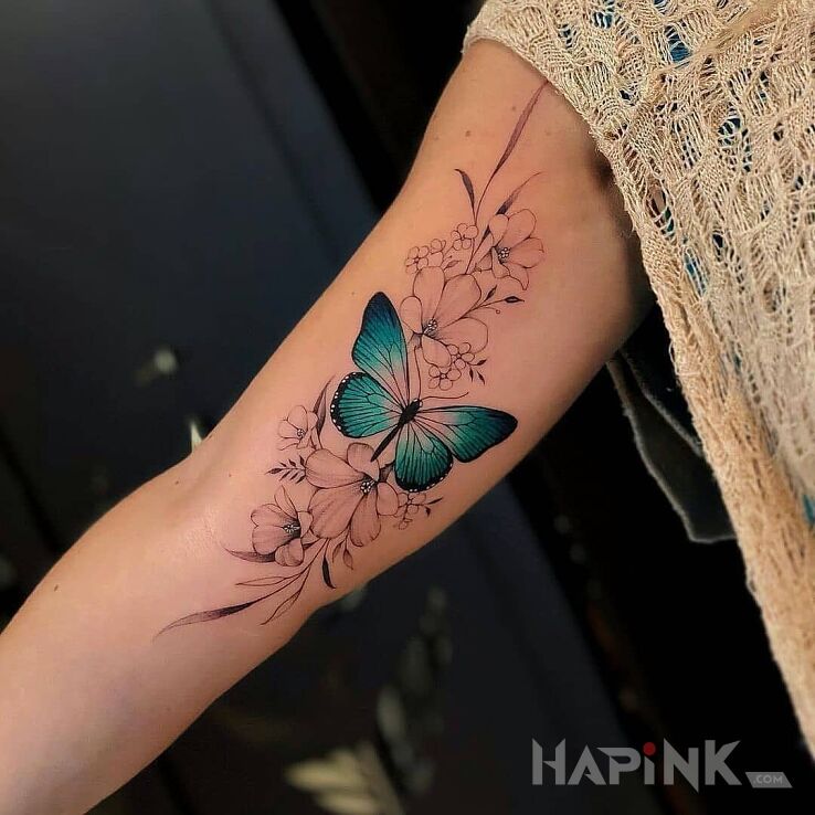 Tattoo Turkusowy motyl in colorful motif and realistic style on the upper arm