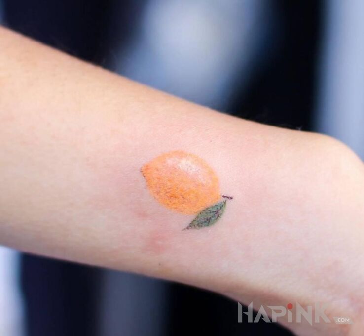 Tattoo Cytrynka in colorful motif and handpoke style on the forearm