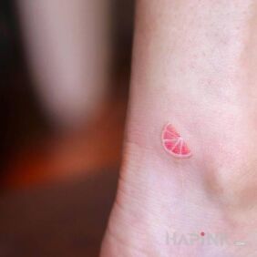 Tattoo Piece of grapefruit near the ankle motif: colorful style: minimalistic