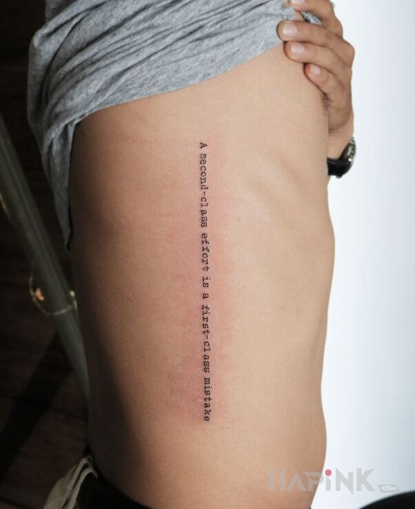 Tattoo Wysiłek in lettering motif and calligraphy style on the ribs