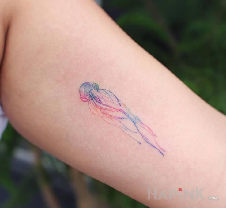 Tattoo Meduza in colorful motif and handpoke style on the upper arm