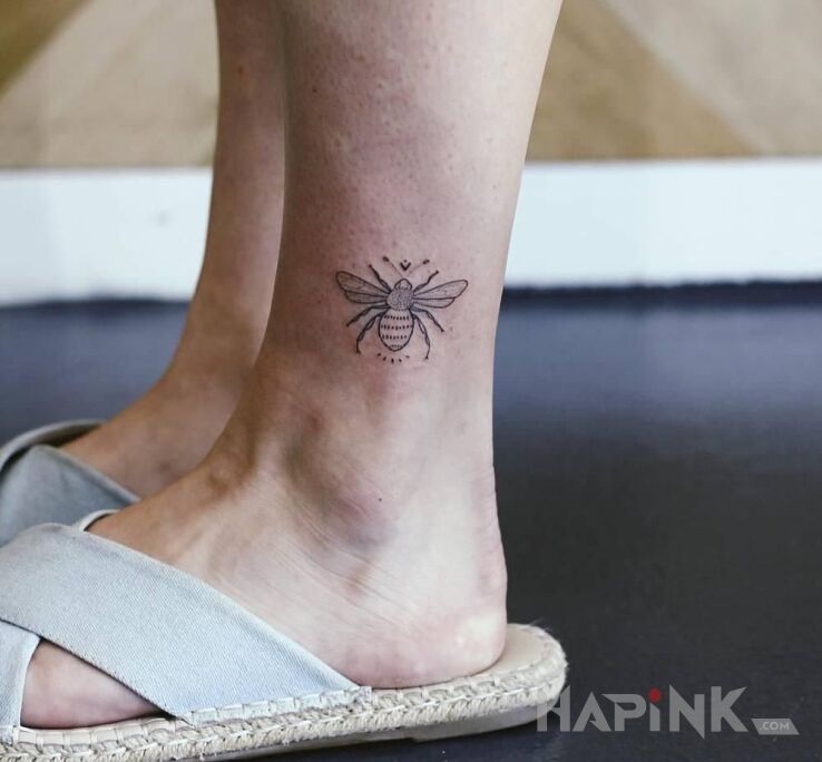 Tattoo Pszczółka in black and gray motif and handpoke style near the ankle