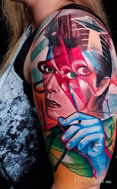 Tattoo David bowie in faces motif and surrealistic style on the upper arm