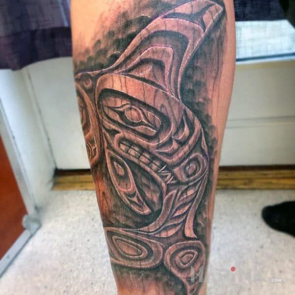 Tattoo Drewniany delfin in animals motif and carved wood style on the calf