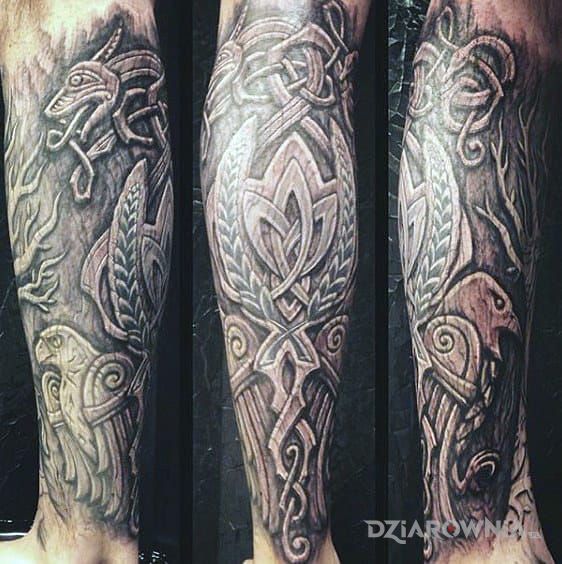 Tatuaż kruki odyna w motywie fantasy i stylu rzeźbione drewno na łydce