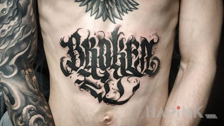 Tattoo Broken in lettering motif and calligraphy style on the stomach