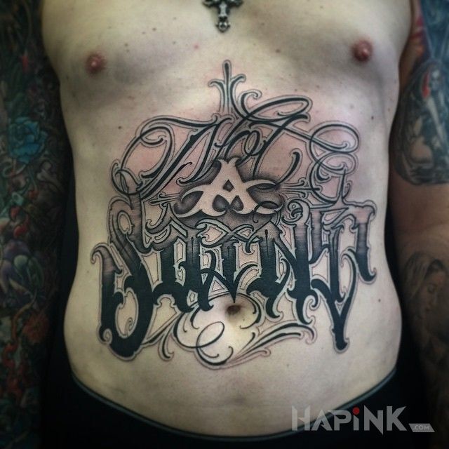 Tattoo Nie jestem swiety in lettering motif and calligraphy style on the stomach