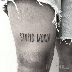 Tattoo Stupid world ☹ on the leg motif: lettering style: ignorant