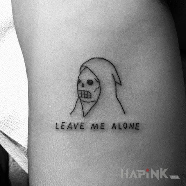 Tattoo Zostaw mnie w spokoju in skulls motif and ignorant style on the forearm