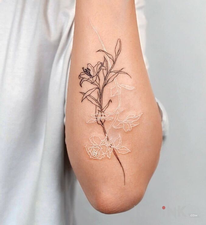 Tattoo Bialy i czarny kwiat in flowers motif and white ink style on the forearm