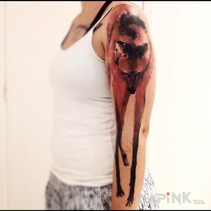 Tattoo Dziwny wilk in animals motif on the upper arm