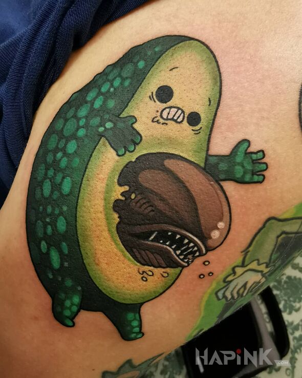 Tattoo Awokado alien ? in characters motif and graphic / illustrative style on the upper arm