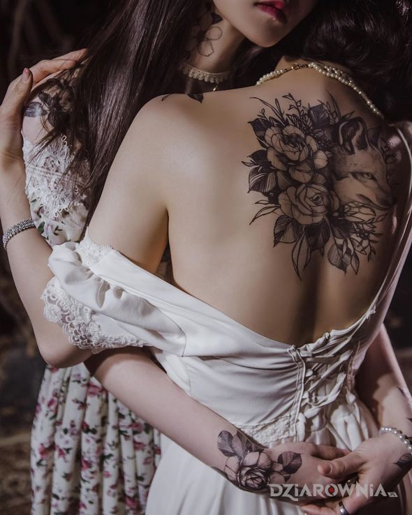 Tatuaż lis wystawia głowę zza kwiatów w motywie kwiaty i stylu realistyczne na nadgarstku