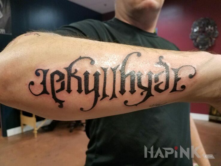 Tattoo Dr Jekkyl / Mr Hyde in lettering motif and ambigrams style on the forearm