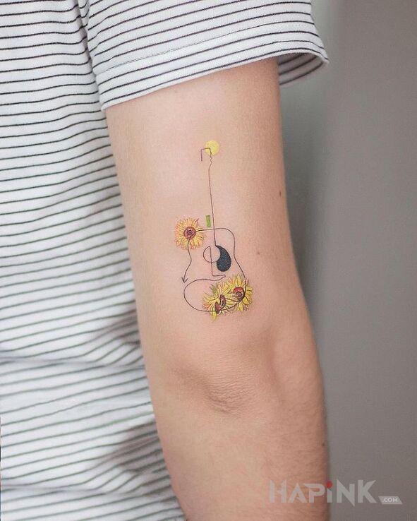 Tattoo No i gitarka in flowers motif and graphic / illustrative style on the upper arm