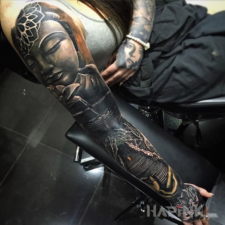 Tattoo Budda in religious motif on the upper arm