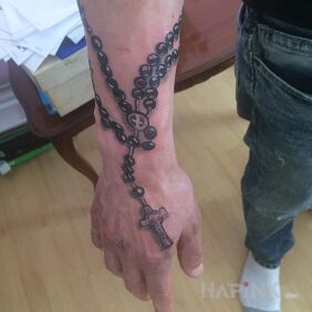 Tattoo Rosary on the hand motif: religious