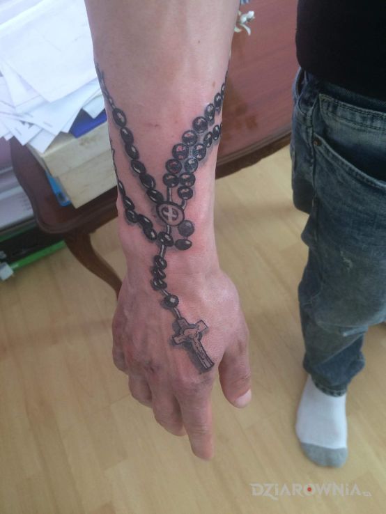 Tatuaż różaniec w motywie religijne na dłoni