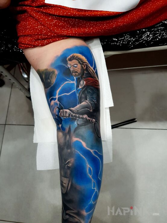 Tattoo Thor in characters motif and realistic style on the upper arm