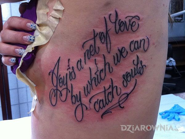 Tatuaż radość i miłość w motywie napisy i stylu kaligrafia na żebrach