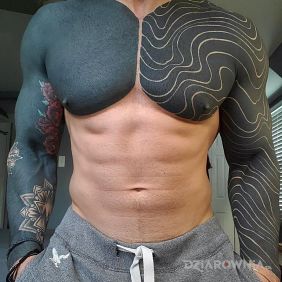Tatuaż Mężczyźni lubią czerń na klatce motyw: czarno-szare styl: blackwork / blackout