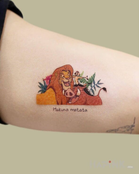 Tattoo Hakuna matata in colorful motif and cartoon / comic book style on the upper arm