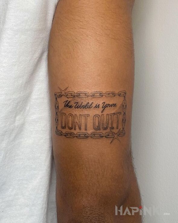 Tattoo Nie rezygnuj in sleeves motif and calligraphy style on the upper arm