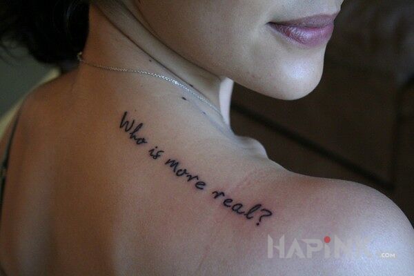 Tattoo Who is more real? in lettering motif on the back