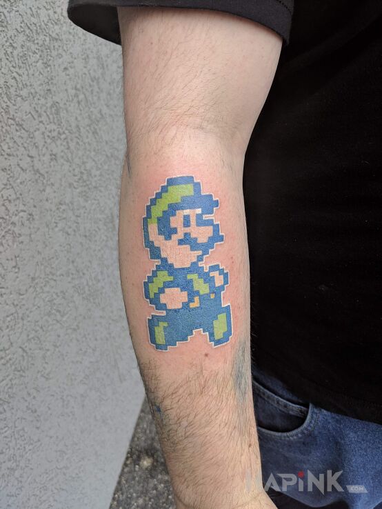 Tattoo Luigi in pixelated motif on the forearm