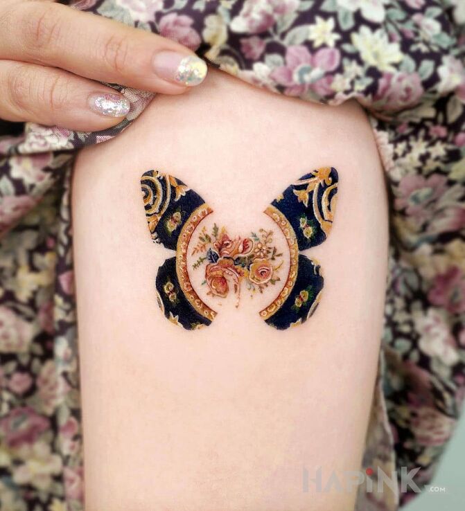 Tattoo Wzorzysty motyl in colorful motif and graphic / illustrative style on the forearm