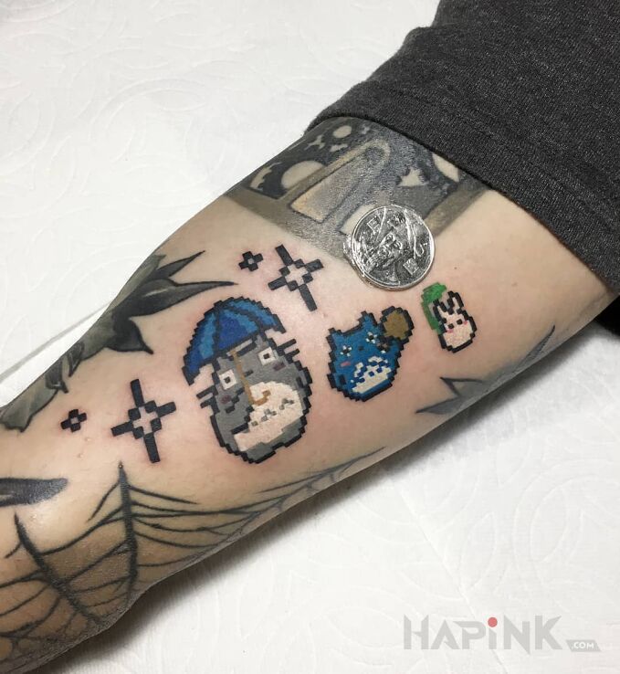 Tattoo Kociaki z pikseli in characters motif on the upper arm