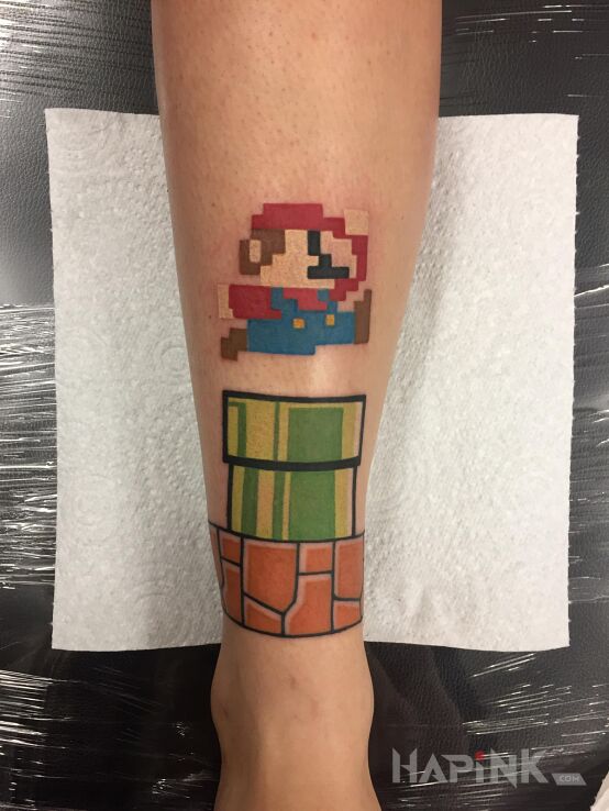 Tattoo Mariano in pixelated motif and graphic / illustrative style on the tibia