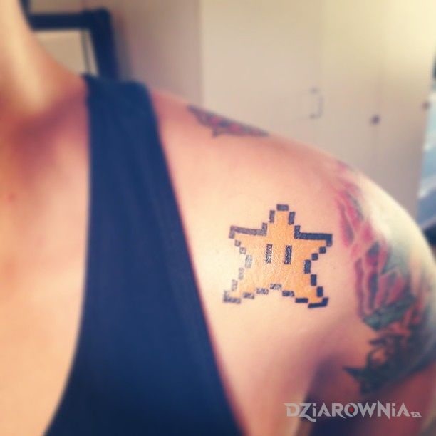 Tatuaż gwiazdka z mario w motywie pikselowane na ramieniu