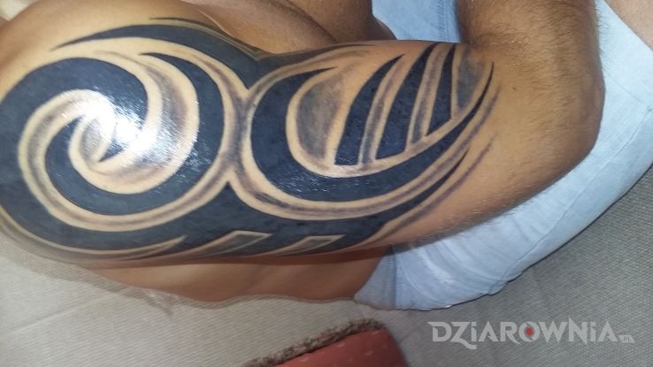 Tatuaż trbal w stylu tribale na ramieniu