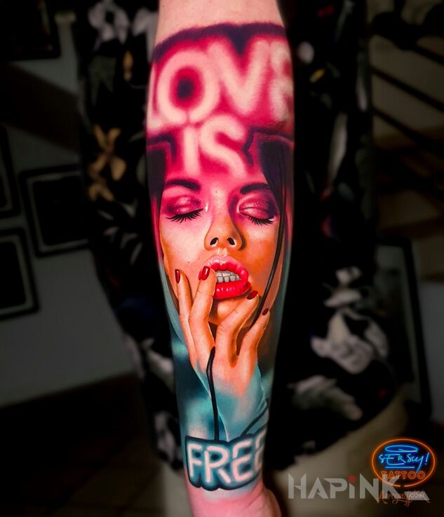 Tattoo Love is Free in colorful motif and realistic style on the forearm