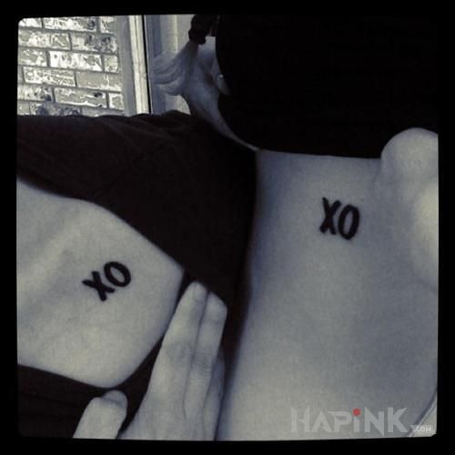 Tattoo XO in lettering motif on the collarbone