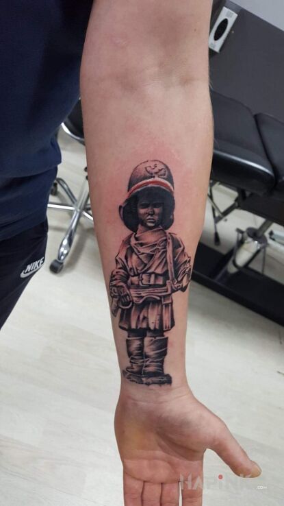 Tattoo Mały powstaniec in characters motif and realistic style on the forearm