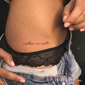 Tattoo She is art on the ribs motif: lettering style: calligraphy