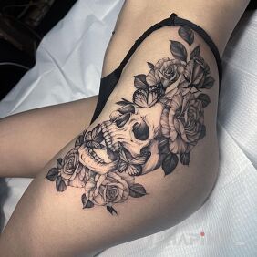 Tattoo Skull with flowers and butterflies on the leg motif: black and gray style: realistic