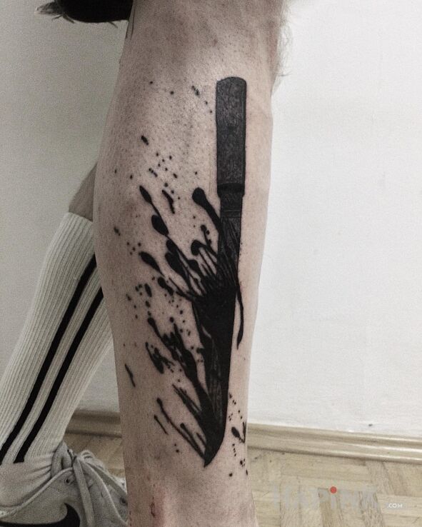 Tattoo Krwawy tantō in black and gray motif and blackwork / blackout style on the leg