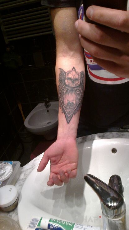 Tattoo Dziki wilk, symbol śmierci in animals motif and realistic style on the forearm