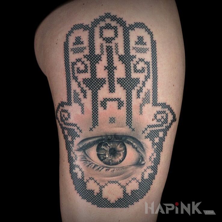Tattoo Ręka fatimy in religious motif and realistic style on the upper arm