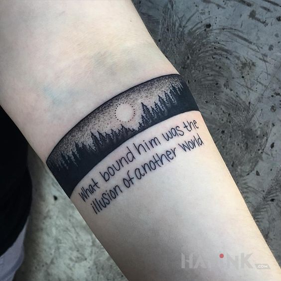 Tattoo Leśna opaska i cytat in black and gray motif and graphic / illustrative style on the forearm