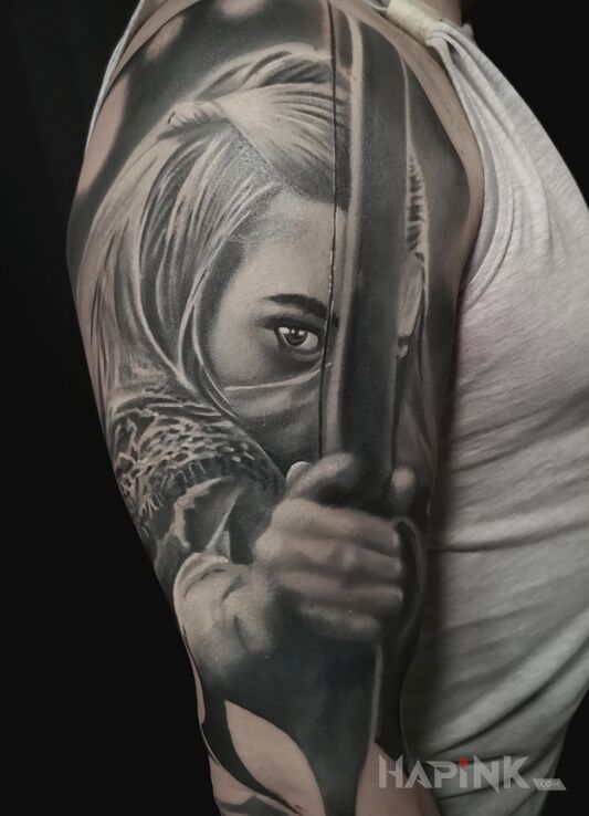 Tattoo Łuczniczka in faces motif and realistic style on the upper arm