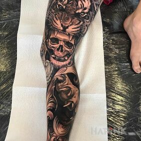 Tattoo Tiger and its paw on the leg motif: black and gray style: realistic