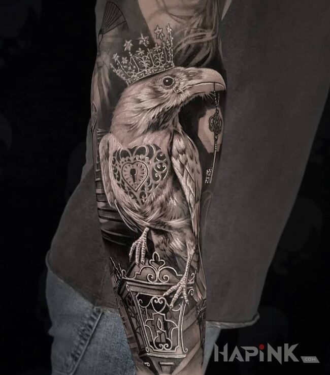 Tattoo Kruk w koronie in black and gray motif and realistic style on the forearm